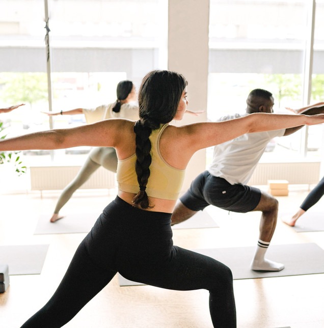 Teilnehmerin in der Kriegerstellung beim Yin-und-Yang-Yoga
